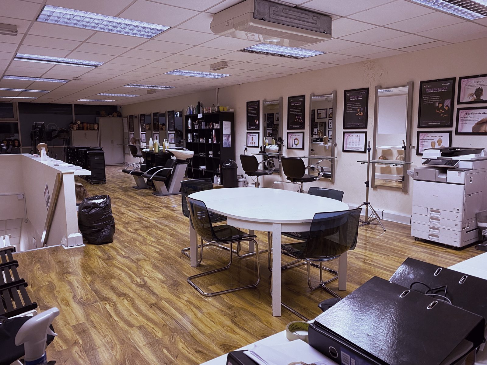 Wide view of the Feltham hair and barbering hub with styling stations, basins and the shared table
