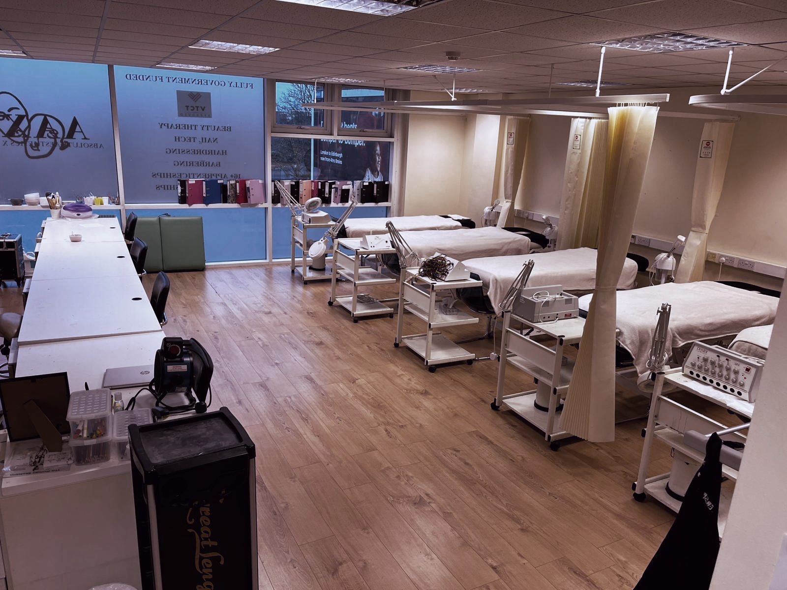 Wide view of the Feltham beauty and nails salon with treatment beds, nail desks and window graphics