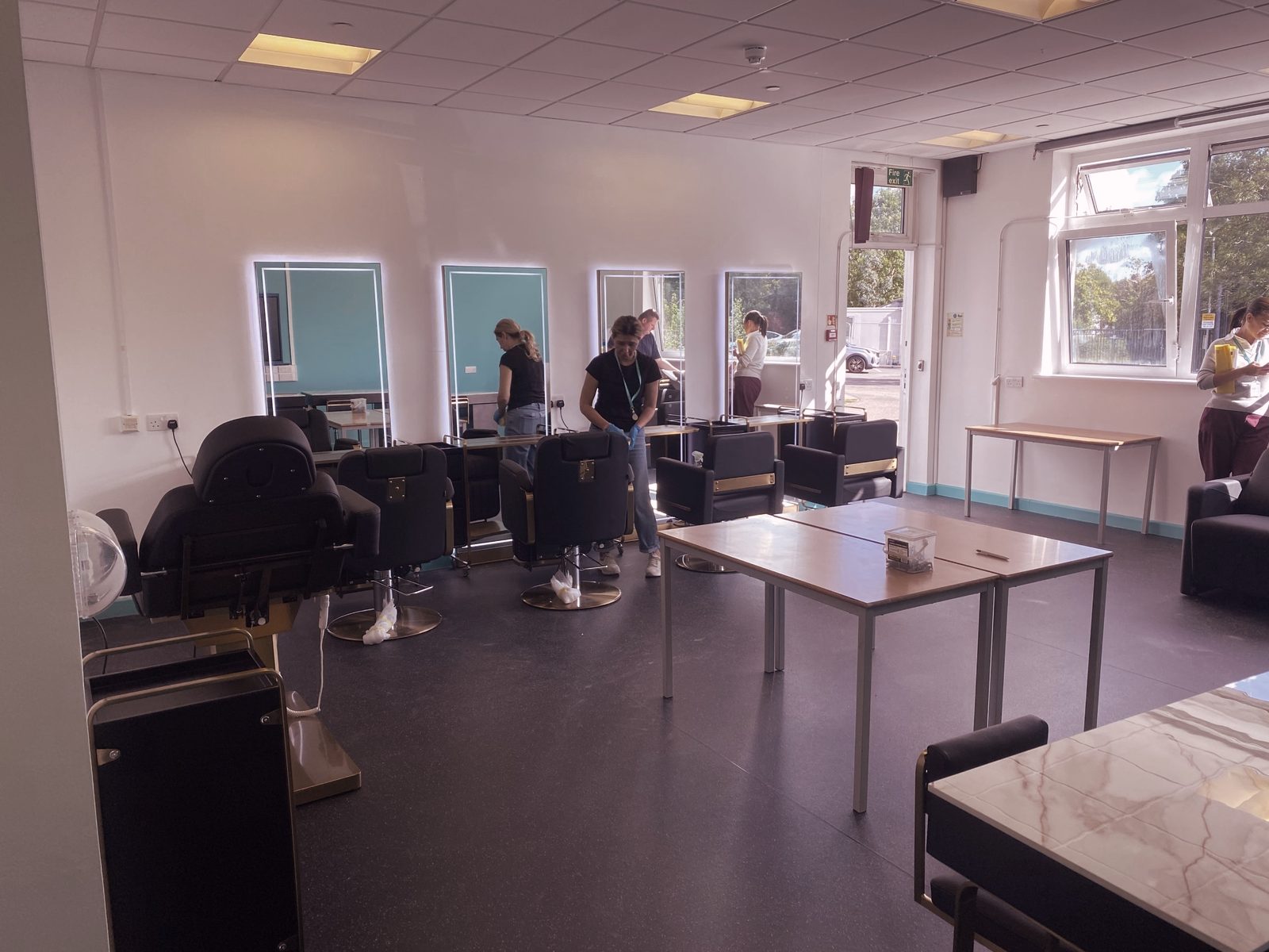Wide view of the EAP-Extend partnership salon in Ealing with lit mirrors and styling chairs