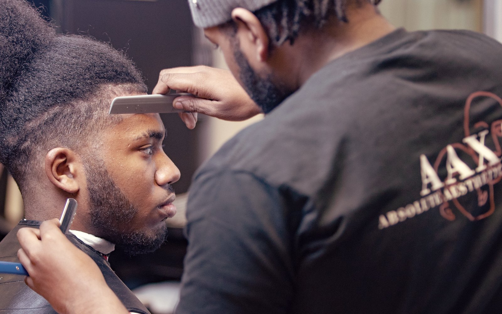 An AAXA barber working on a skin fade