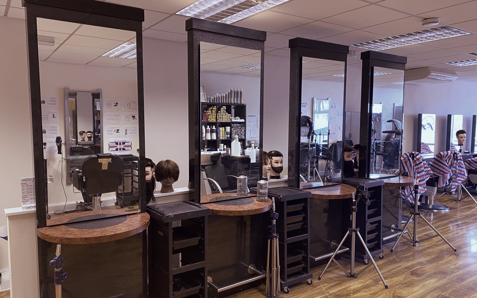 Styling stations with tall mirrors and practice heads at the Feltham hair and barbering hub